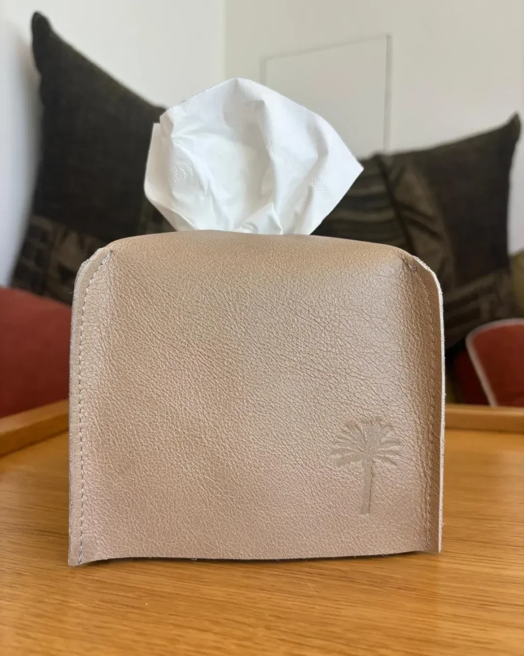 Handmade tan leather tissue box cover with embossed palm tree logo, crafted by local artisans in Cape Town for sustainable hotel amenities, by Soli.