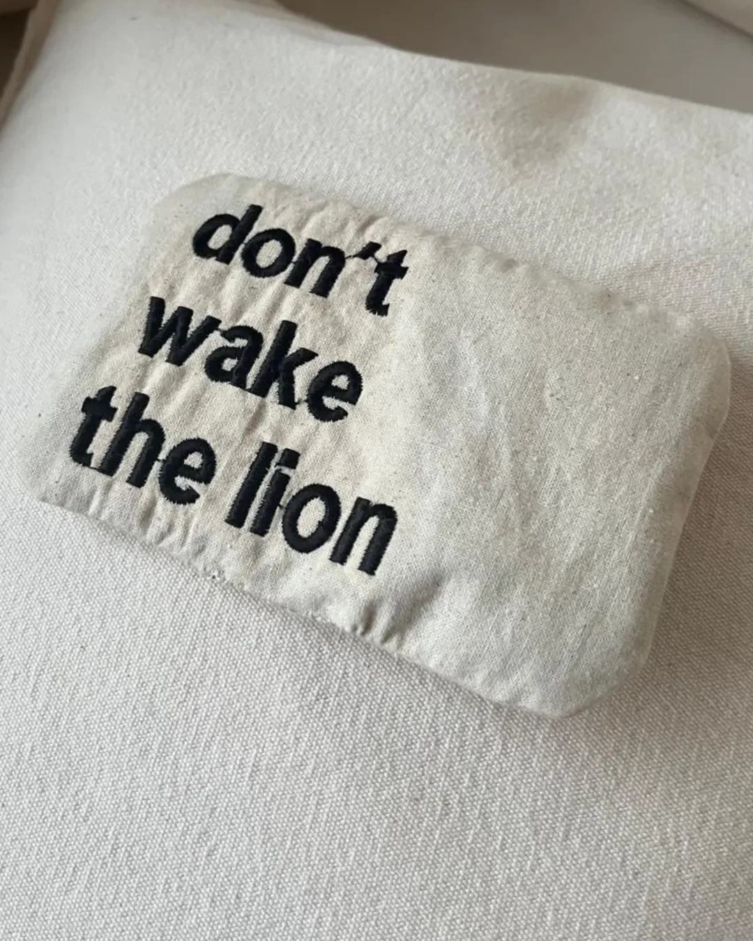 Embroidered lavender bag in calico cotton featuring the text "don't wake the lion," a handmade sustainable corporate gift by Soli in Cape Town.