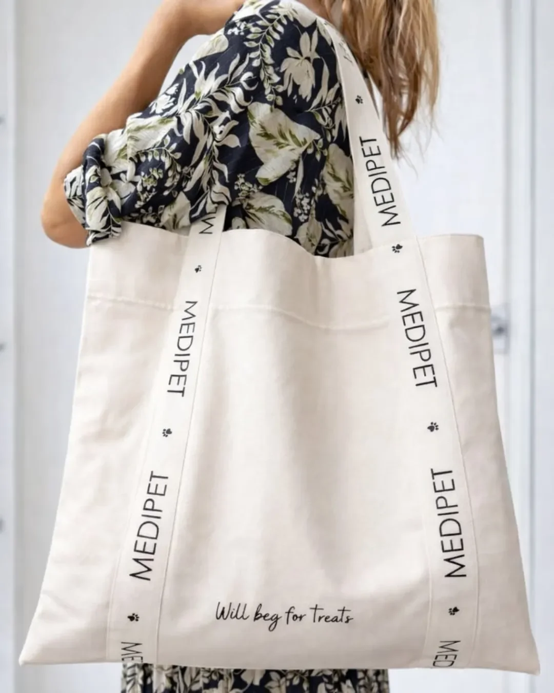 A women carrying custom branded signature strap bag in natural bull denim with personalized logo handles with the words " MEDIPET". Handmade by Soli in Cape Town for sustainable merchandise or corporate gifts.