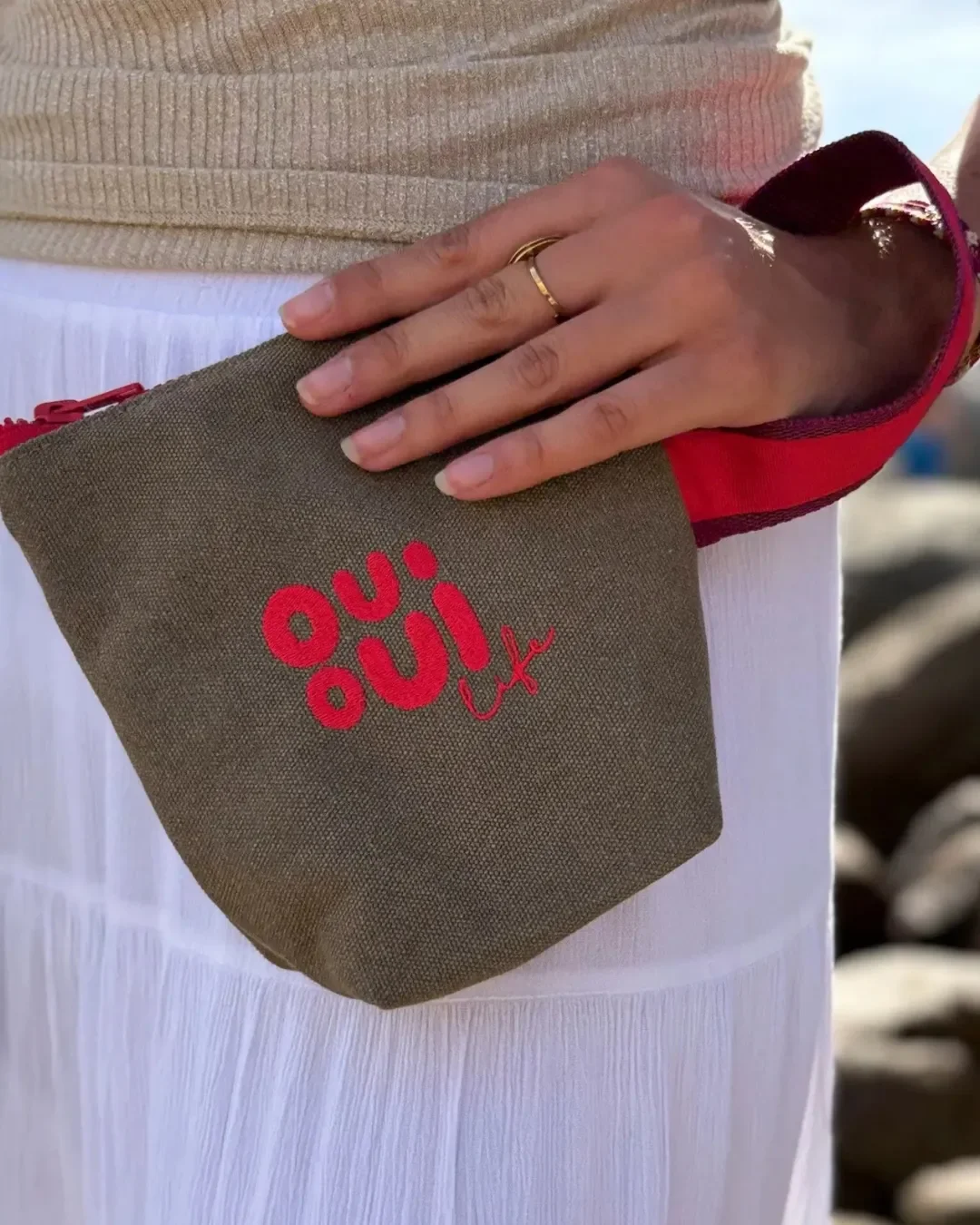 Handmade Berlin cosmetic pouch in olive green canvas with red embroidered logo and matching strap, a sustainable corporate gift by Soli Cape Town.