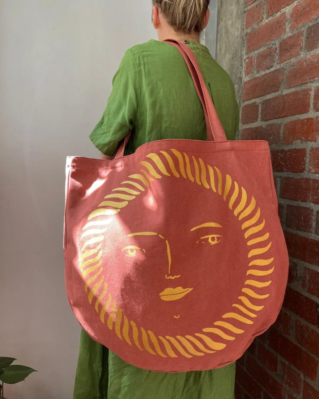 Terracotta pink canvas Sun Bag with a yellow hand-drawn sun face graphic, Handmade by Soli in Cape Town for sustainable merchandise or corporate gifts.