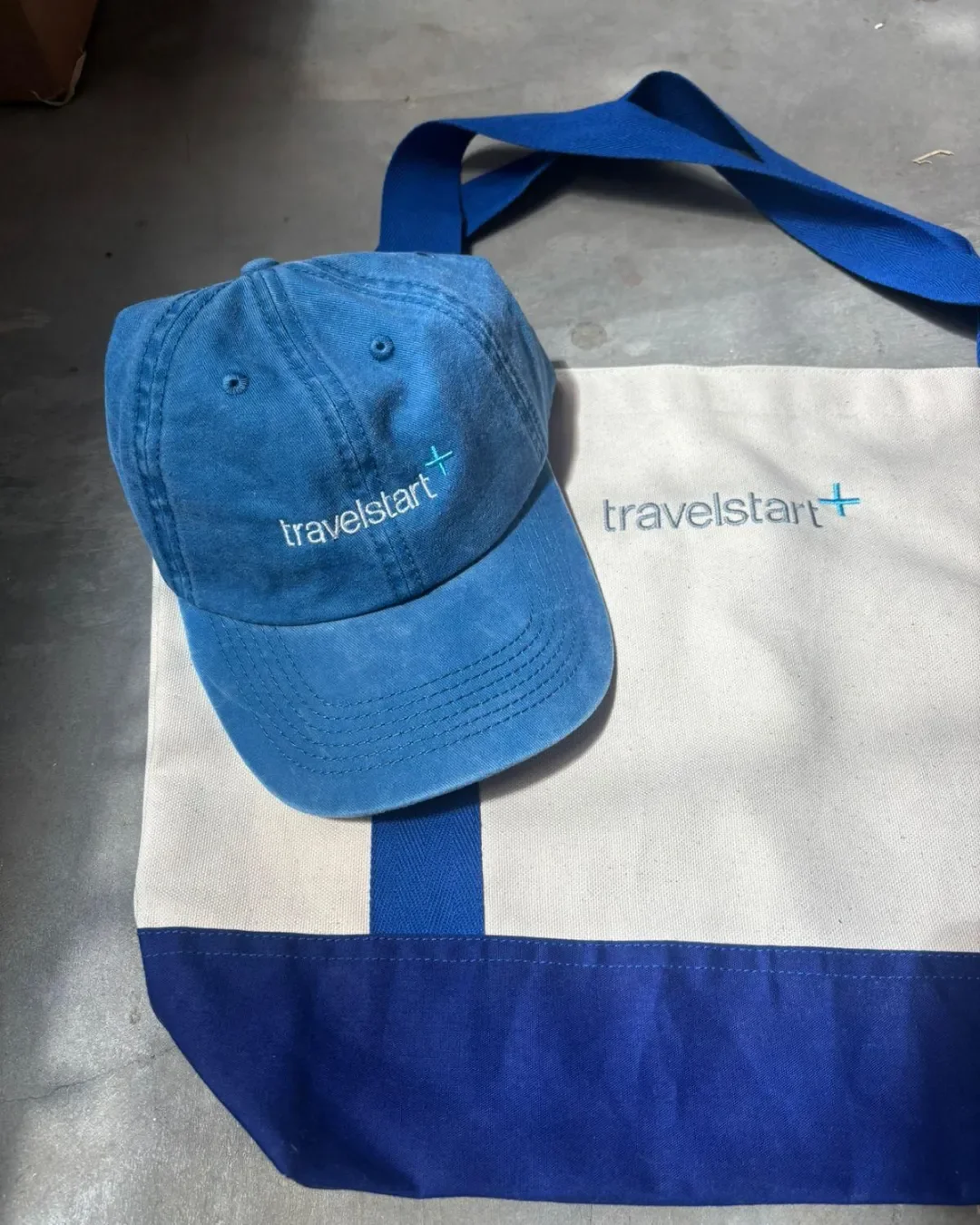 Custom-branded Milano tote bag made from heavy cotton canvas and a blue embroidered baseball cap, handmade by artisans in Cape Town for sustainable corporate gifting and merchandise.