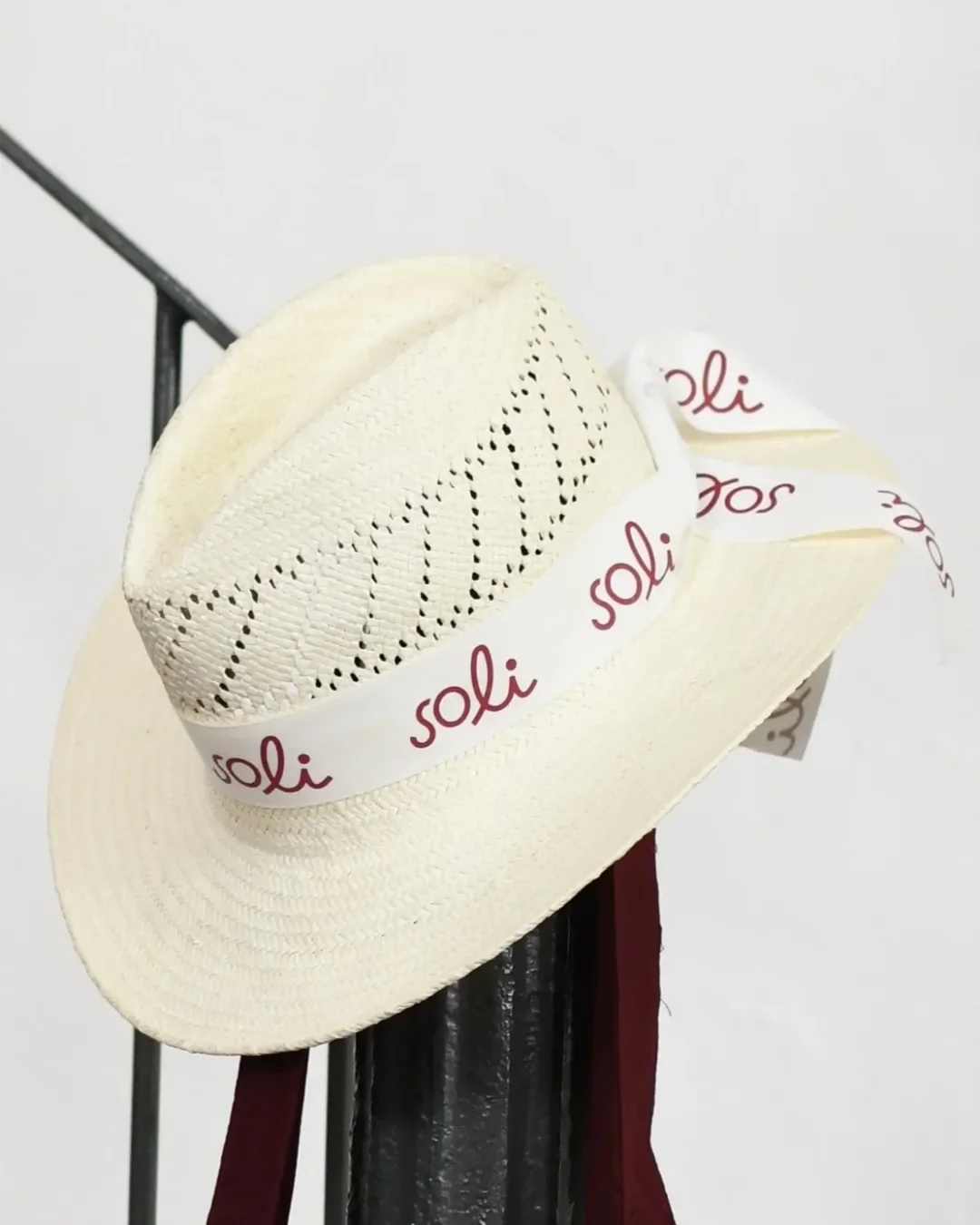 Model wearing a Soli Panama style woven straw hat with a custom branded logo bandana, a premium sustainable corporate gift customized in South Africa.
