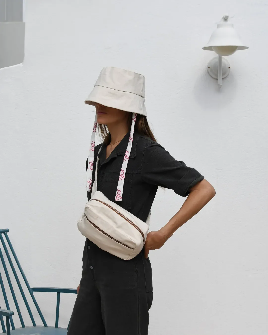 Woman wearing a Soli custom heavy canvas bucket hat in cream with branded logo ribbons, handmade in Cape Town as a sustainable corporate gift.