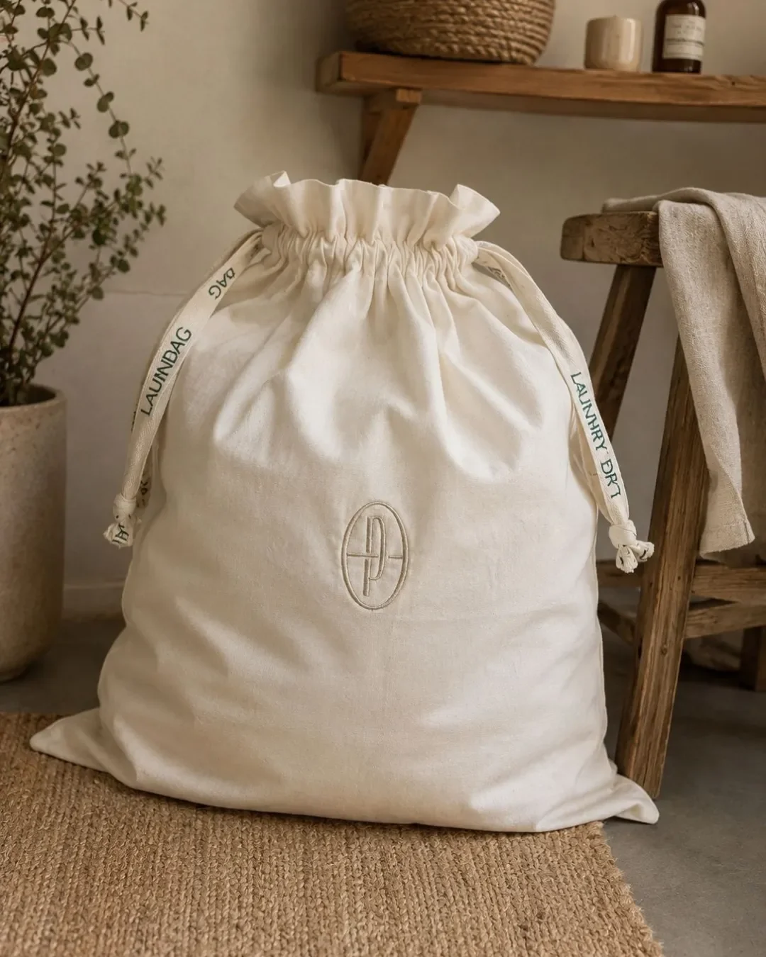 Custom embroidered natural cotton laundry bag for hotels and guestrooms, handmade by Soli in Cape Town for sustainable merchandise or corporate gifts.