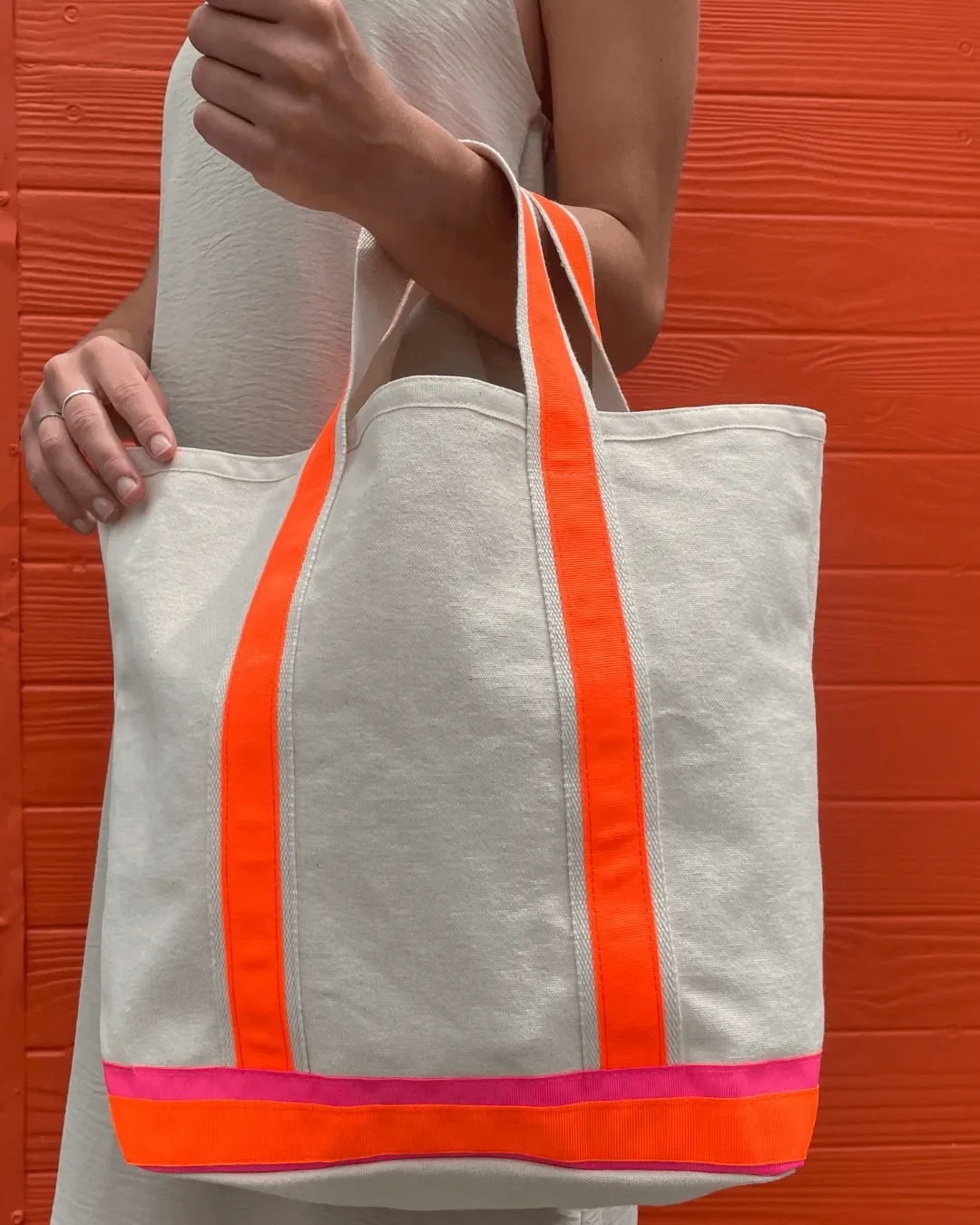 Neon Clementine tote bag handmade from heavy 510gsm natural cotton canvas featuring bright orange straps and a pink base stripe, crafted by local artisans in Cape Town.