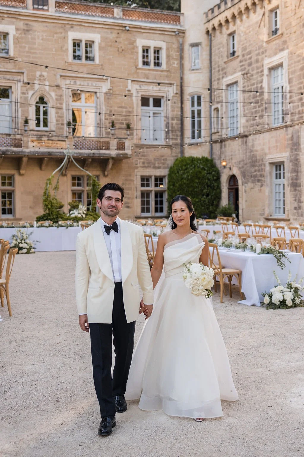 Bride and groom in the stone courtyard of Château de Beauregard, set for an elegant wedding reception in Provence, France