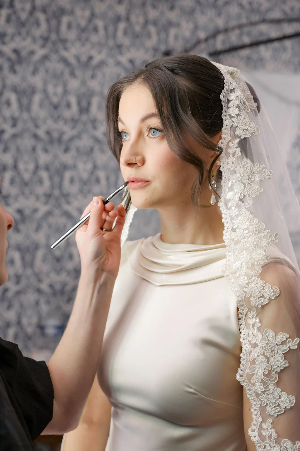 Close-up of the bride having her wedding makeup applied, soft glowing skin and a lace veil, bridal makeup in Provence by Mathilde Vintze