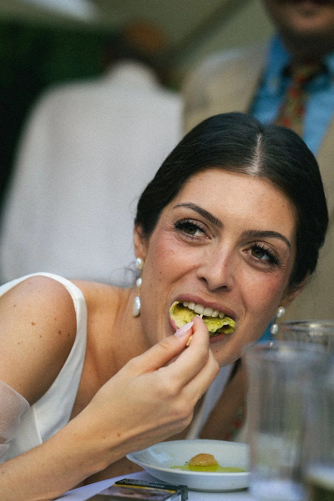 Candid moment of the bride at the wedding dinner. Long-wear bridal makeup that stays fresh from morning to evening reception.