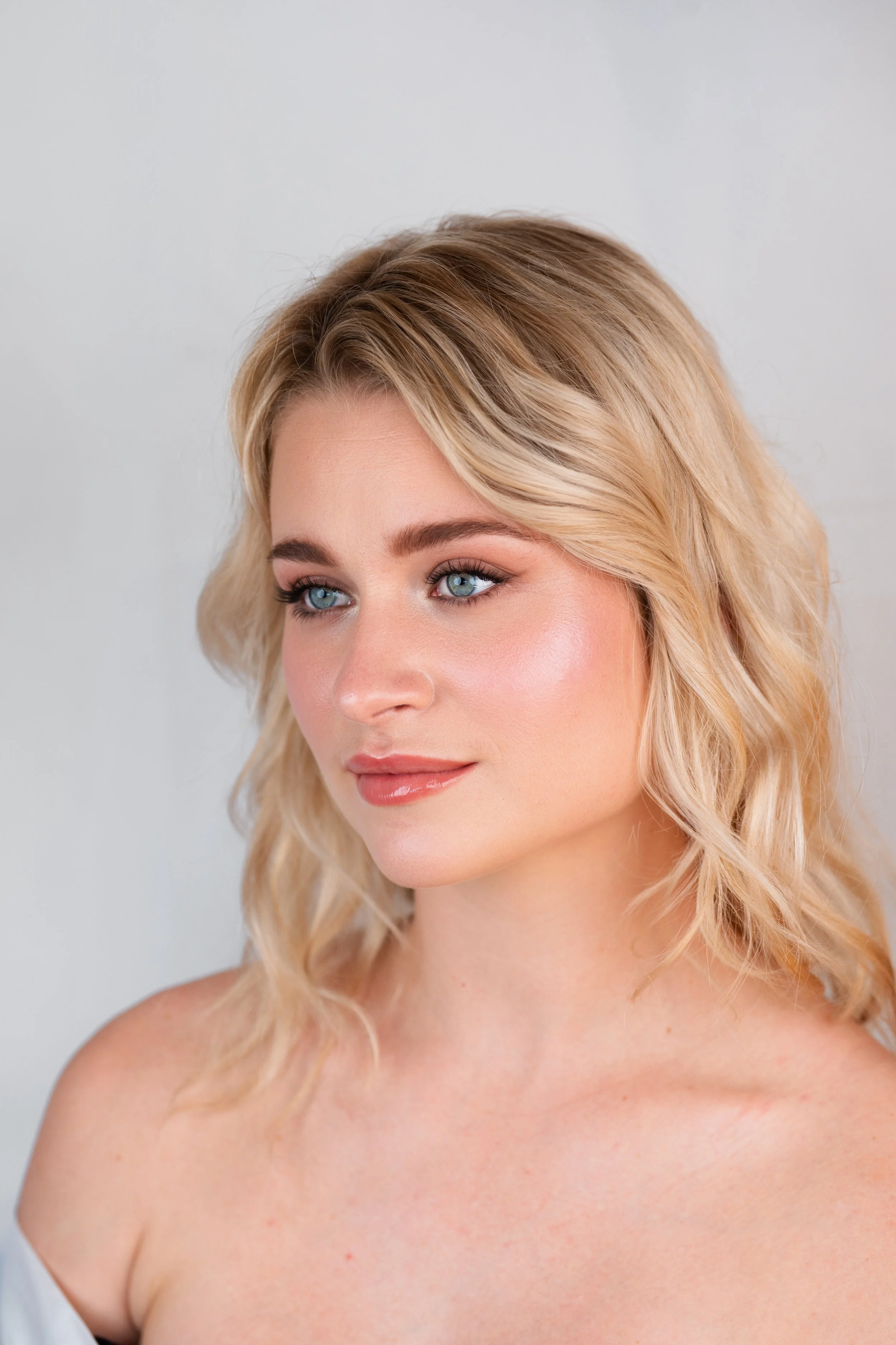 Blonde bride with wavy hair and luminous, natural bridal makeup by Mathilde Vintze, wedding makeup artist in Provence
