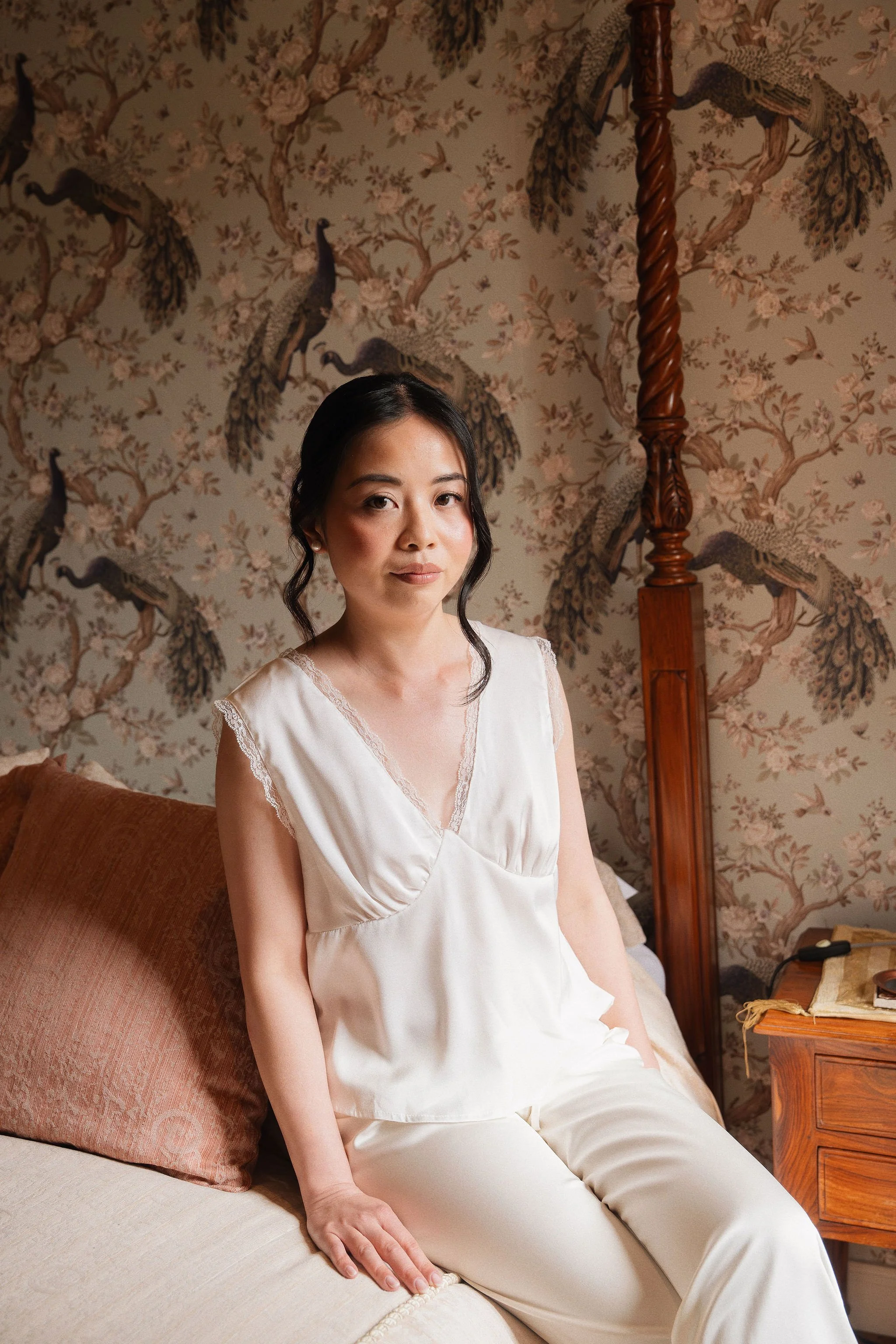Bride getting ready in a bridal suite with peacock wallpaper, bridal hair and makeup in Provence
