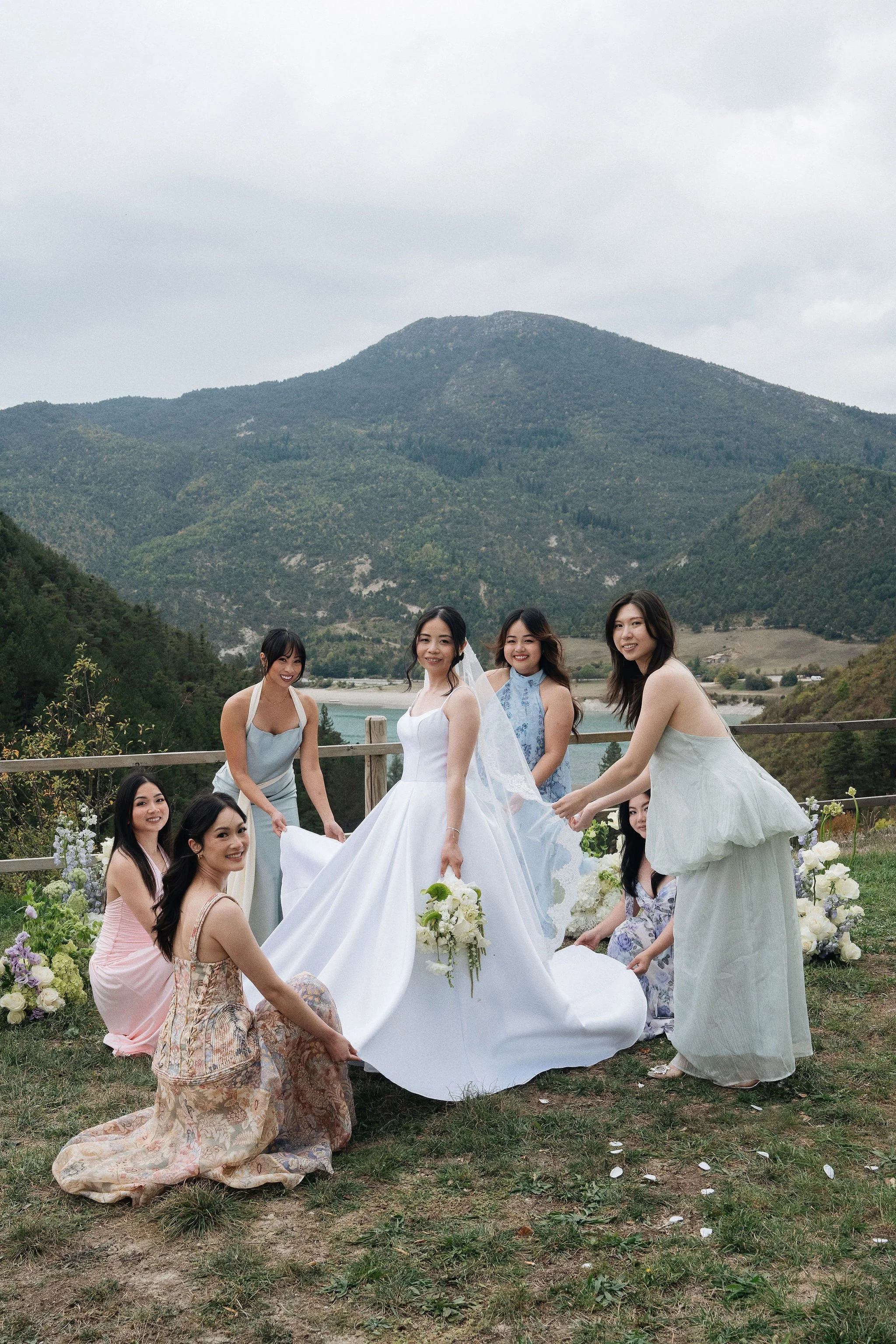 Bride and bridesmaids in pastel dresses with mountain view, intimate wedding at Château de Méouilles, Alpes-de-Haute-Provence
