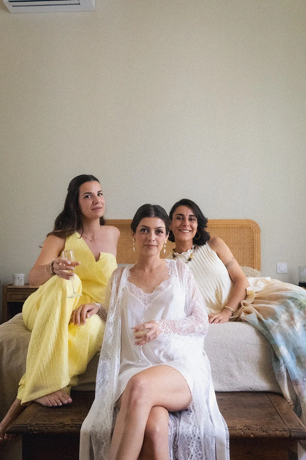 The bride in a lace robe, surrounded by her loved ones before the ceremony. A calm wedding morning and natural bridal makeup in Provence.