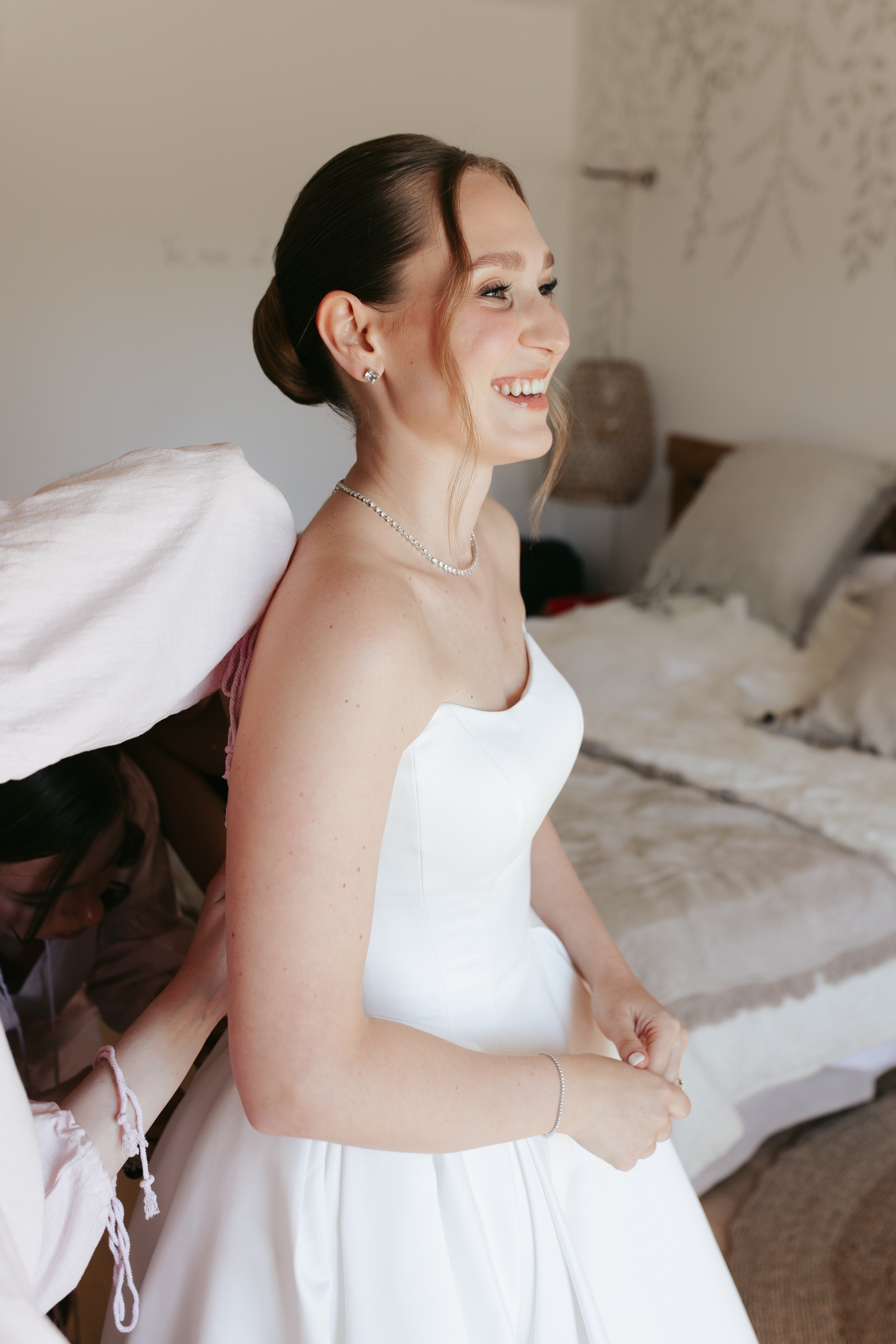 Close-up bridal beauty portrait highlighting glowing skin, soft eye makeup and a chic updo created by Mathilde Vintze Artistry for a luminous wedding-day look.