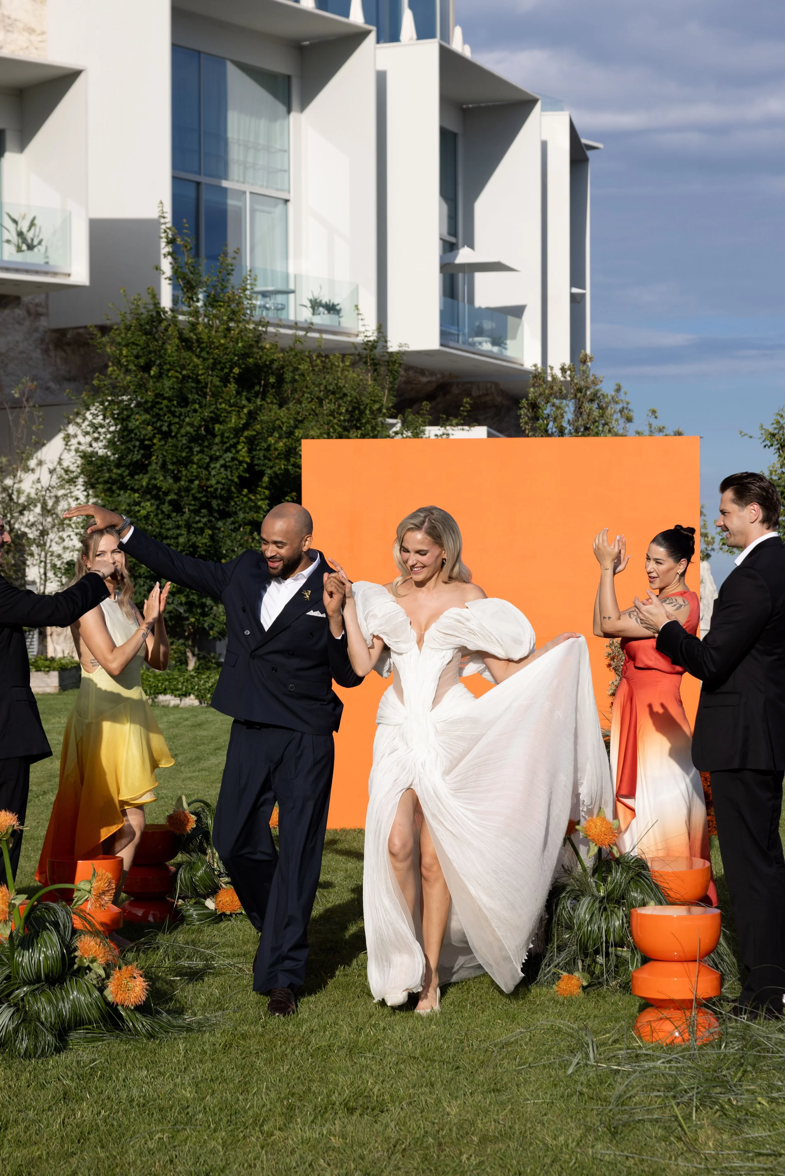 Newlyweds walking back down the aisle through applauding guests on the lawn at The Maybourne Riviera, destination wedding makeup by Mathilde Vintze