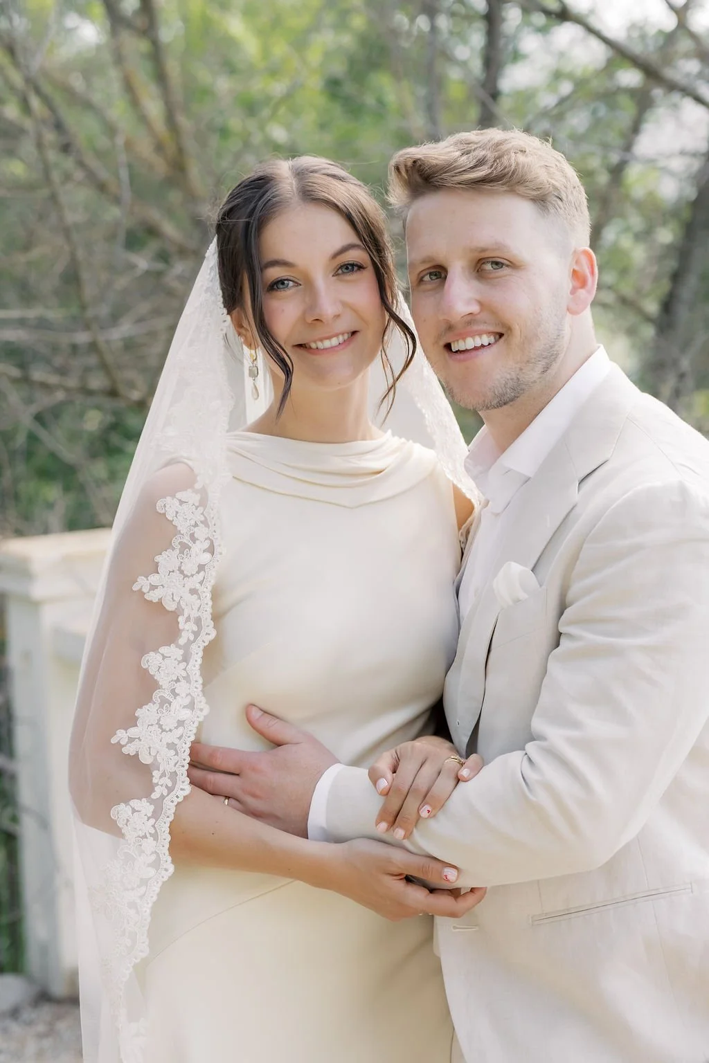 Close bride and groom portrait, the bride in a lace veil with luminous skin and soft natural wedding makeup by Mathilde Vintze in Provence