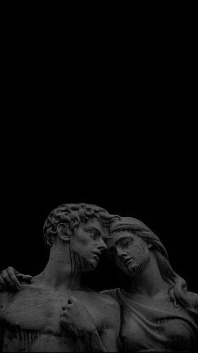 Escultura clásica de un hombre y una mujer en un abrazo, en tonos gris oscuro.