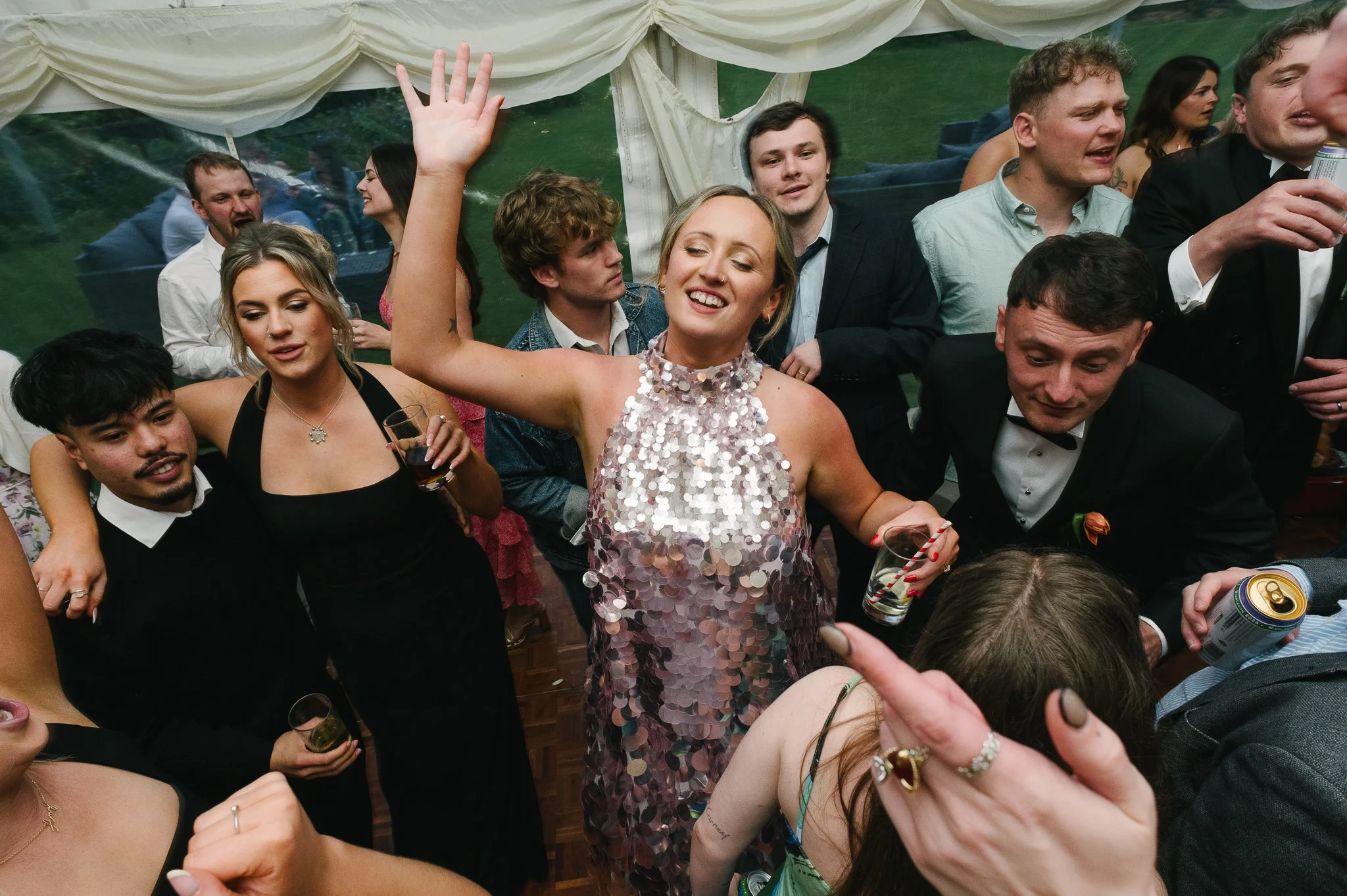Bride on the dancefloor in a happy world of her own surrounded by dance floor chaos