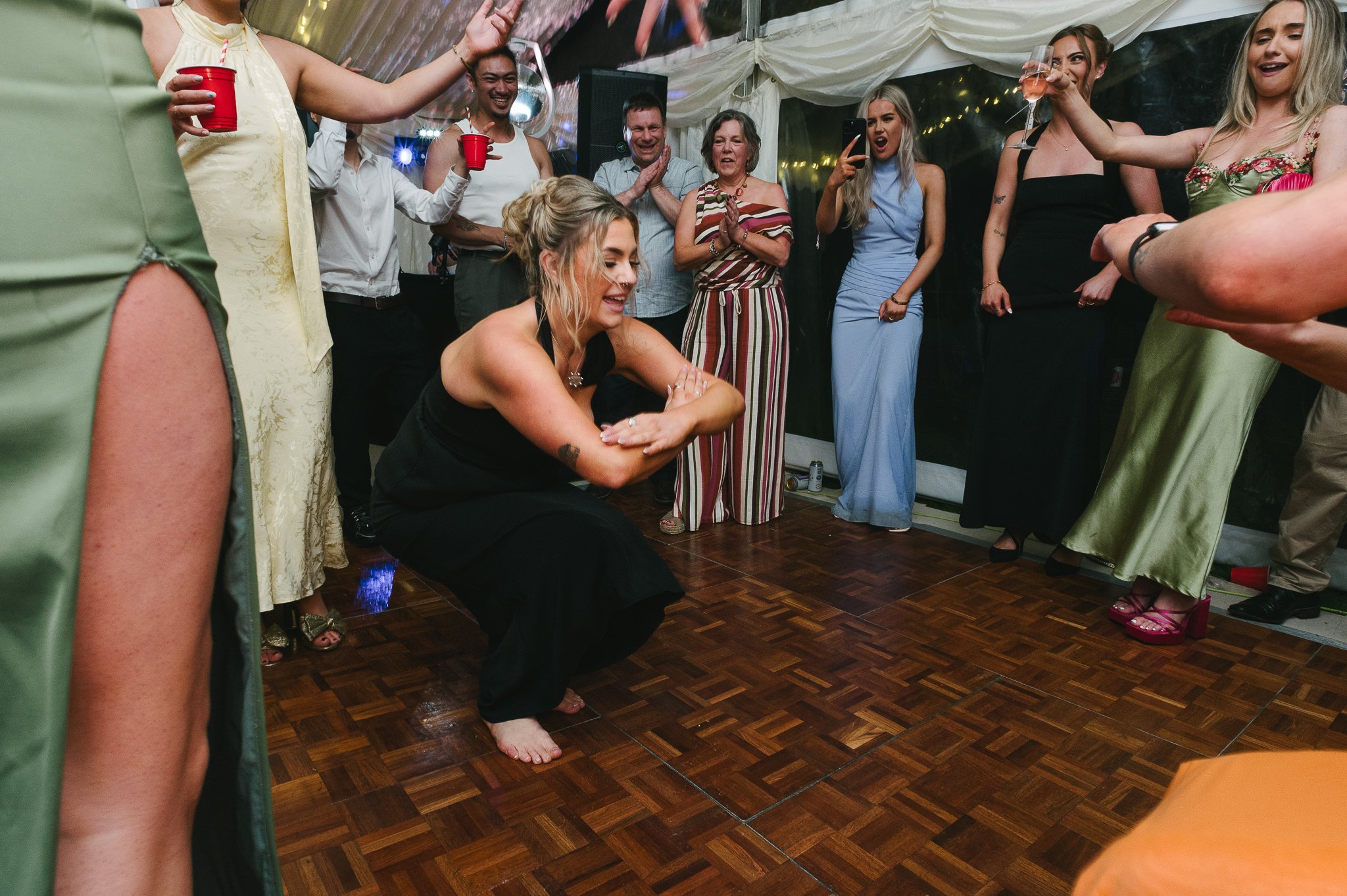 cossack dancing bridesmaid surrounded by the party on the dance floor