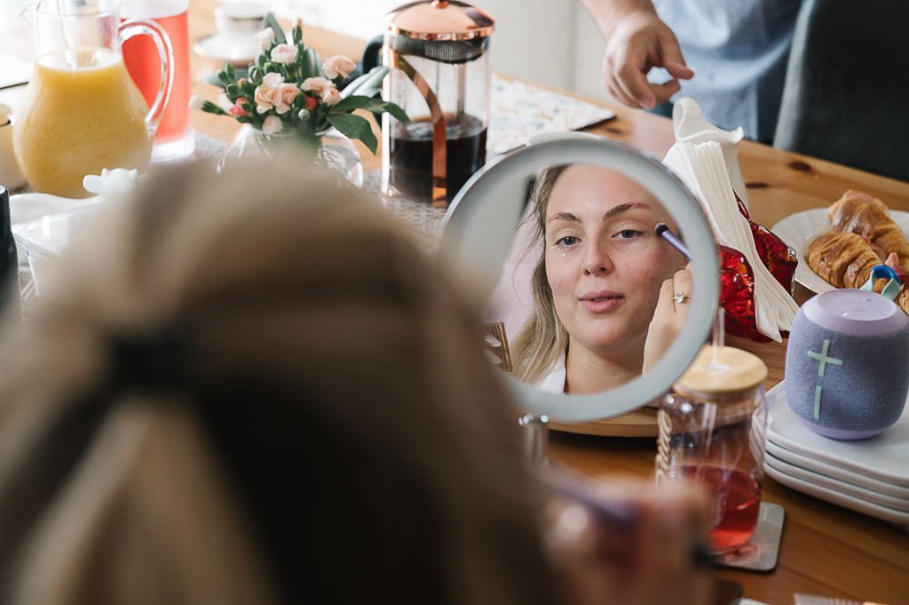 Bride putting makeup on