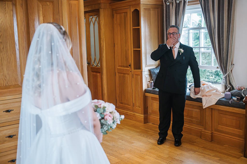 Father of the bride sees her in her dress for the first time