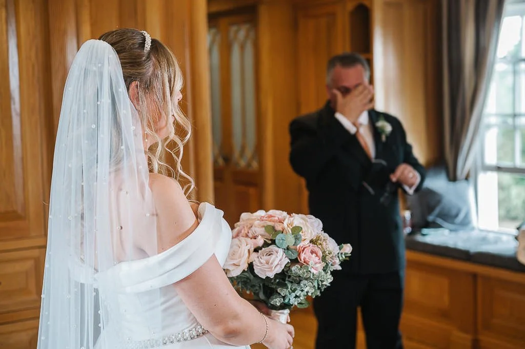 Father of the bride sees her in her dress for the first time