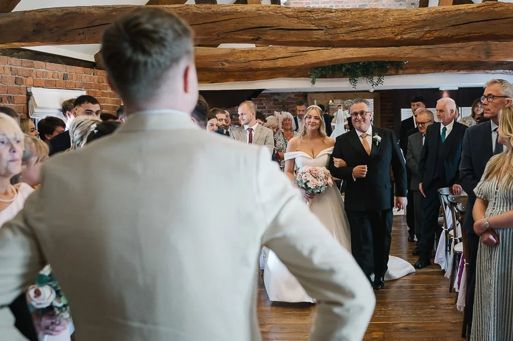The bride arrives while the groom waits for her