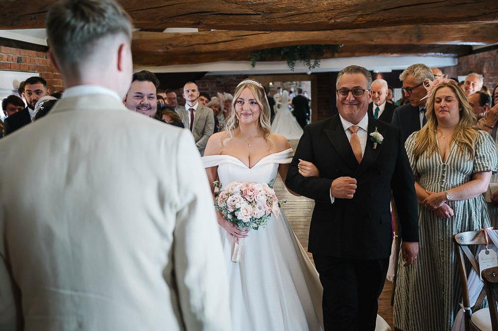 The bride walking down the aisle at the ceremony at Swancar Farm Nottingham