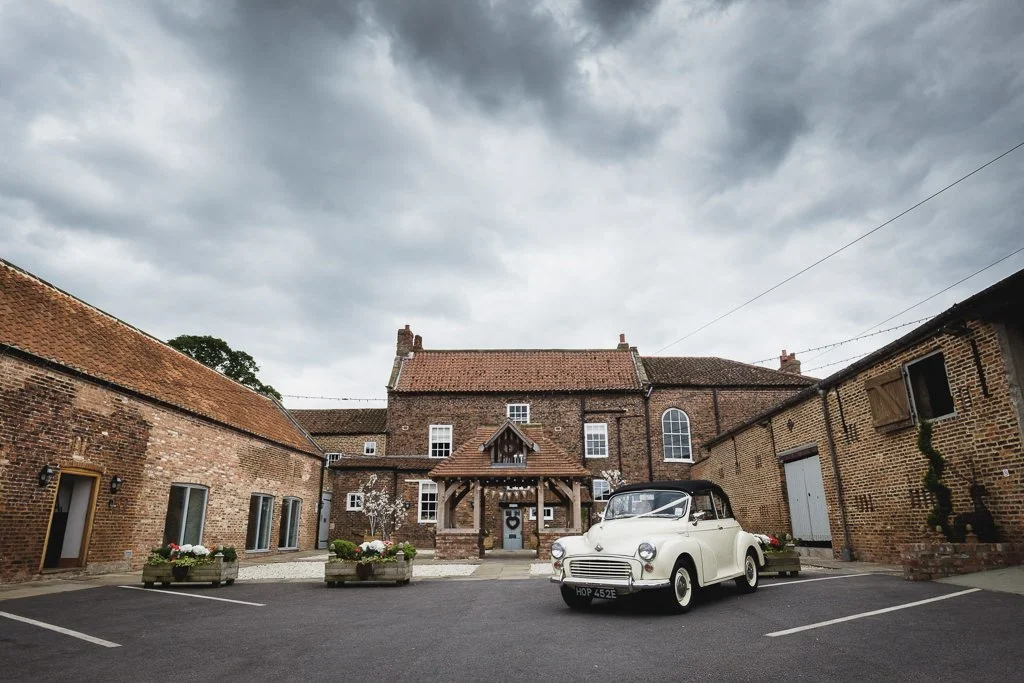Hornington Manor with a vintage Morris Minor Wedding Car parked outside