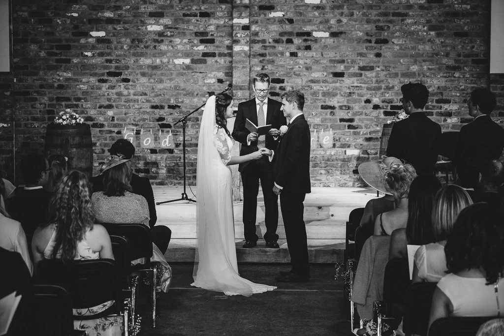 The bride and groom at the front of the chapel during the wedding ceremony