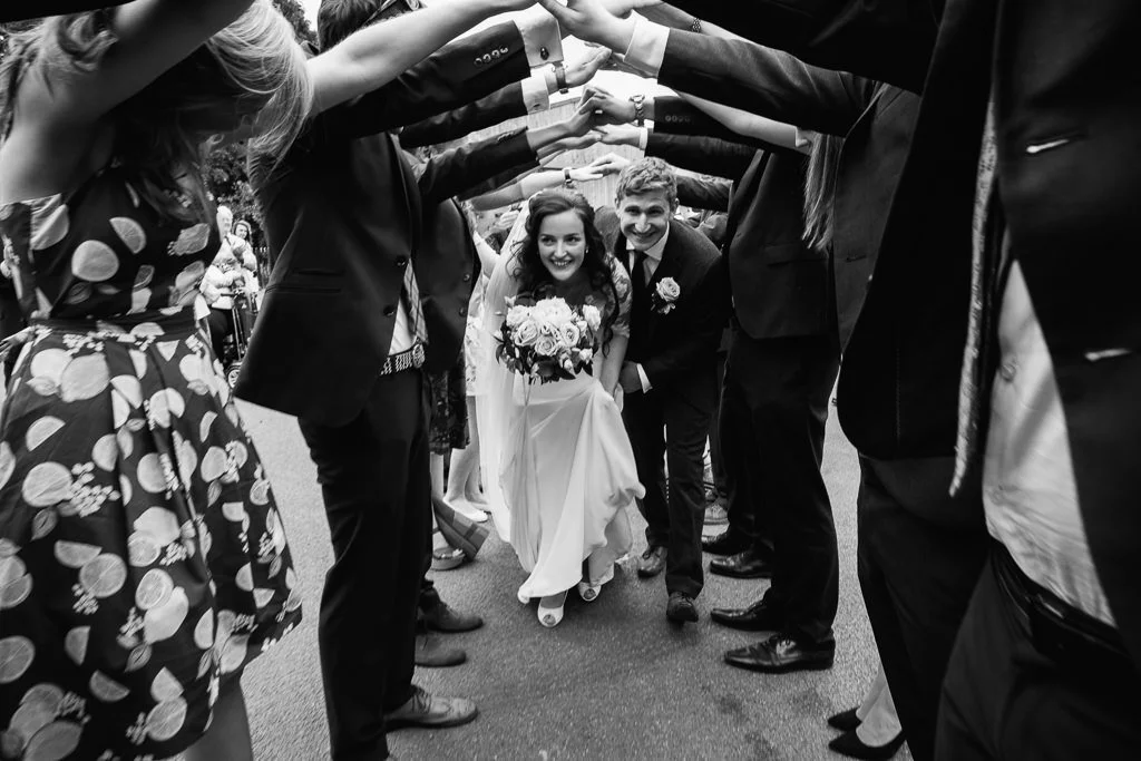 Becky and Josh in an archway made by the guests