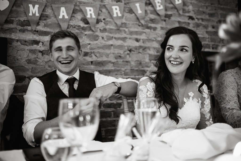 Bride &amp; Groom laughing at the speeches