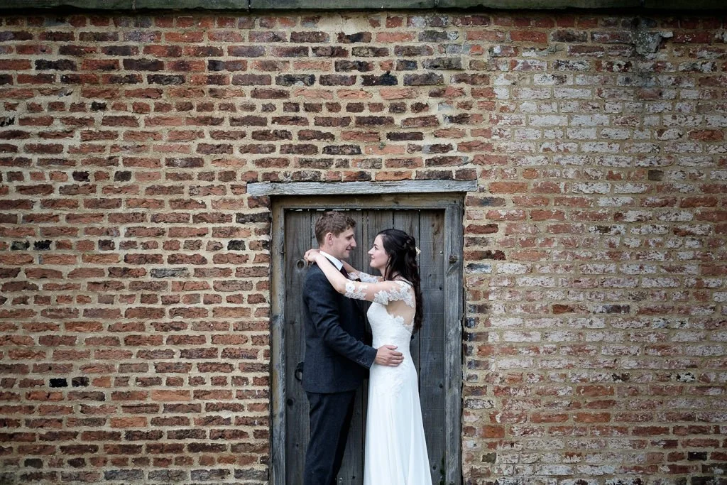 Becky &amp; Josh wedding portrait in front of an old wall