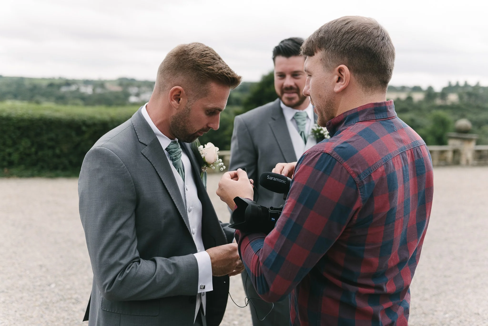 putting a microphone on the groom 