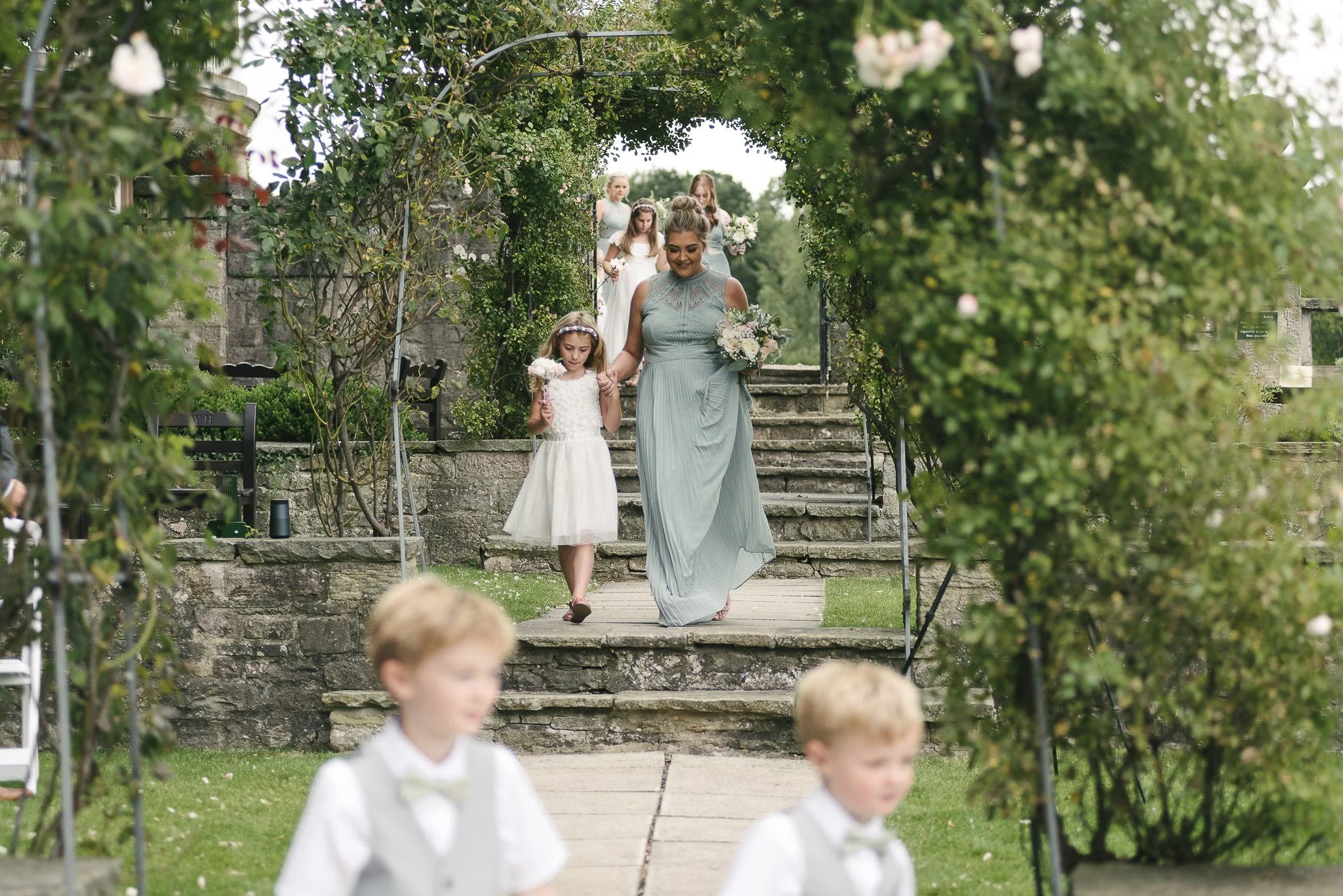Bridesmaids walking down the aisle at the outdoor wedding ceremony
