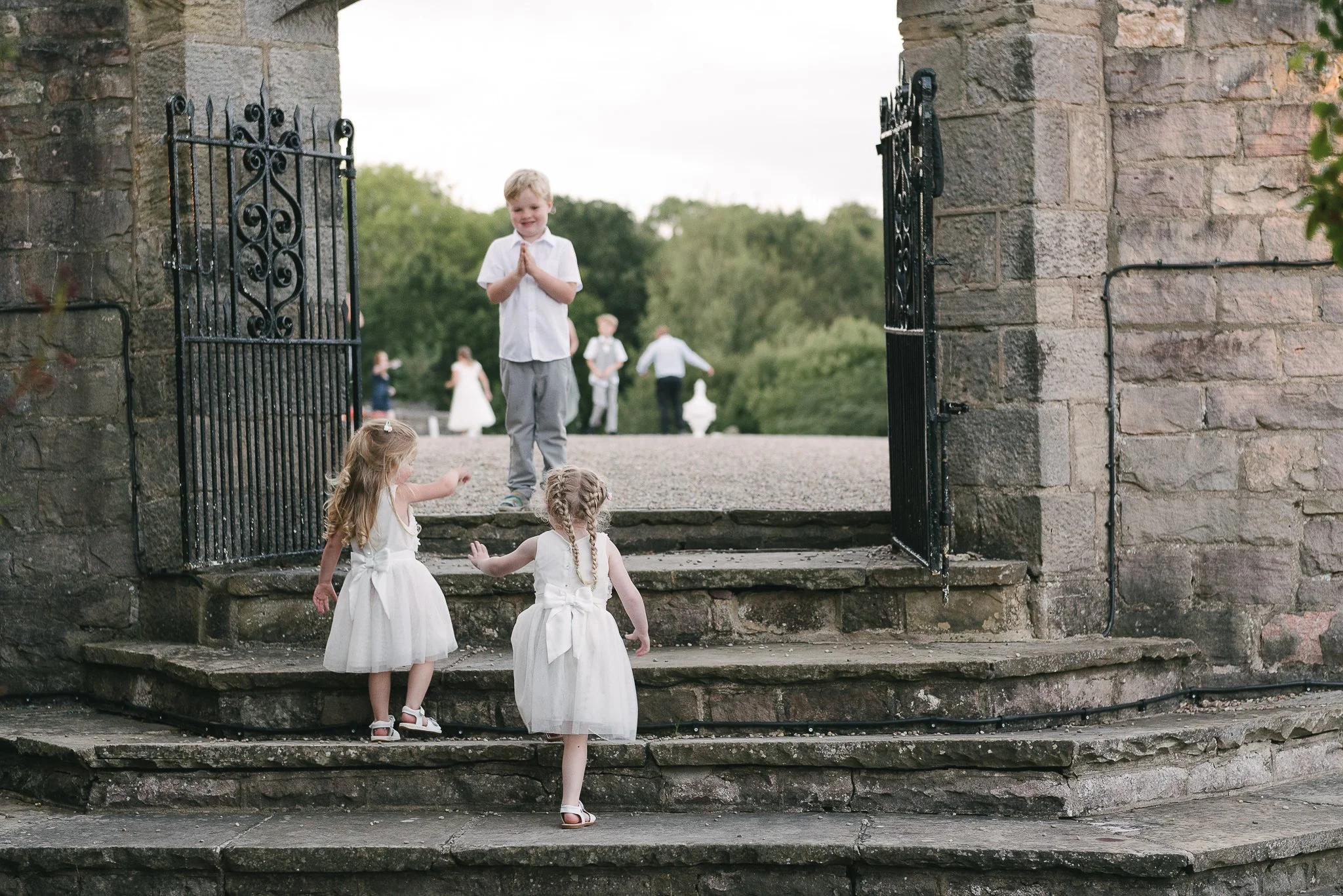 young wedding guests playing on the steps of Wood Hall