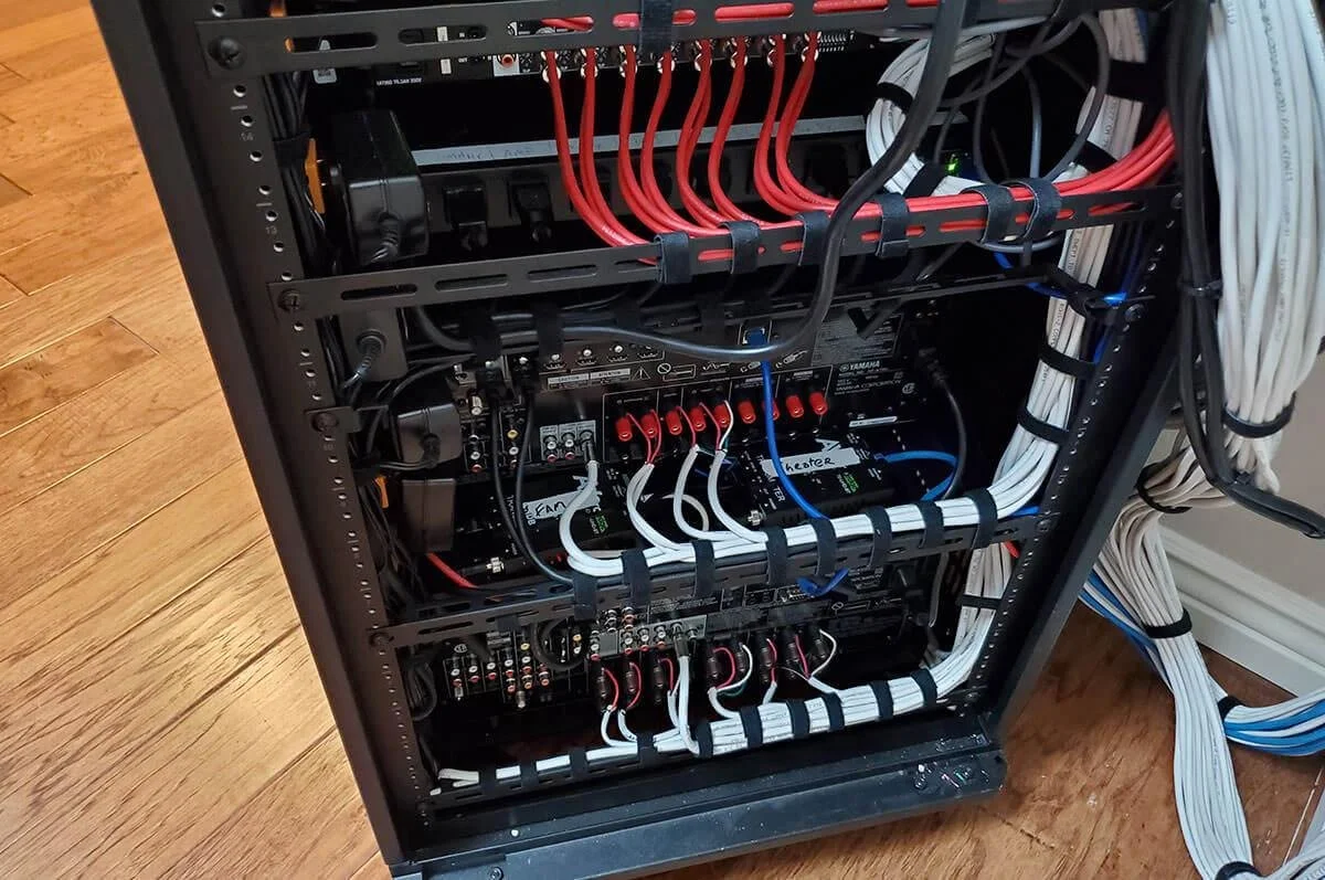 Professional smart home equipment rack with network switches, structured cabling and home automation hardware.