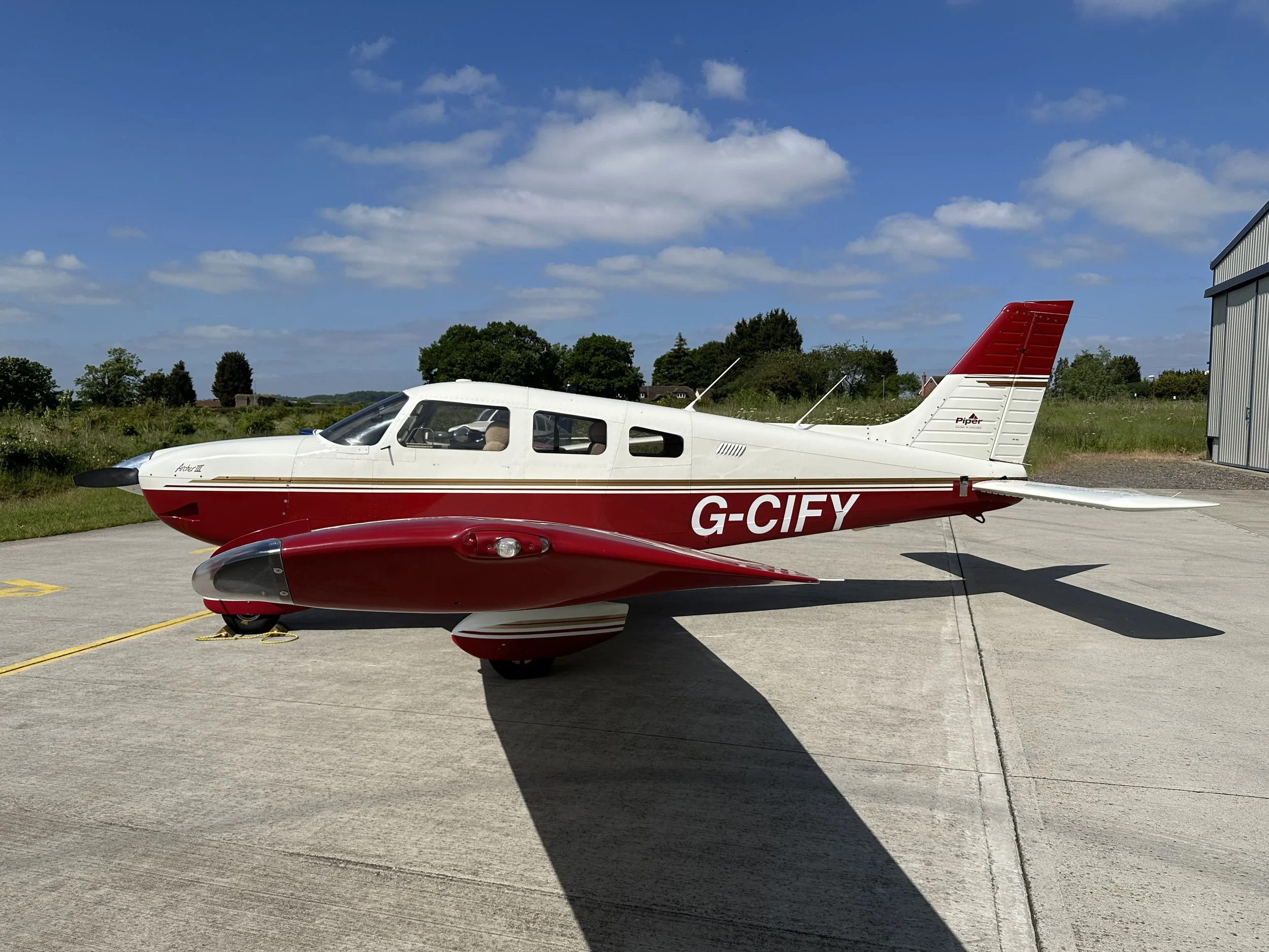 PA28 G-CIFY, Red and white small private airplane on a tarmac