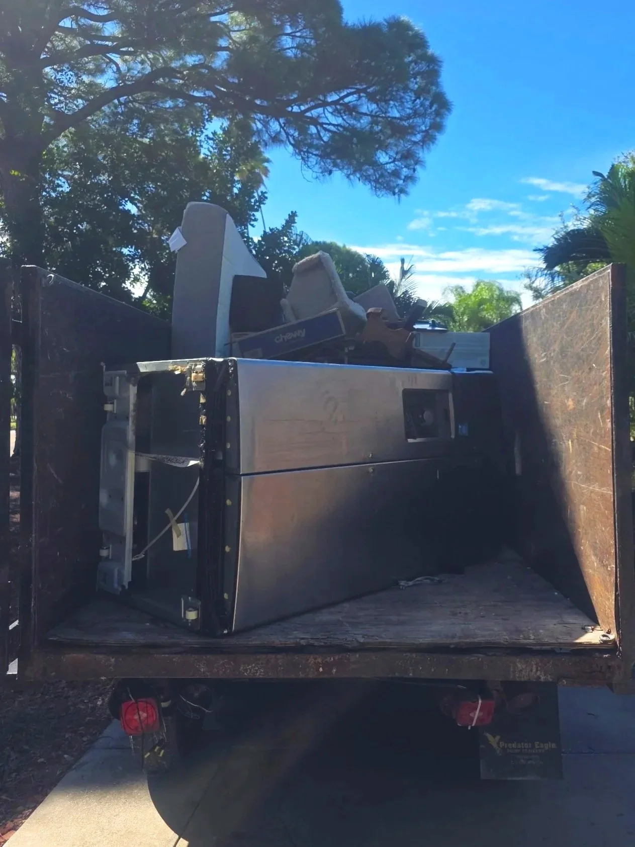 Refrigerator loaded into a Suncoast Hauling Services trailer during an appliance removal job