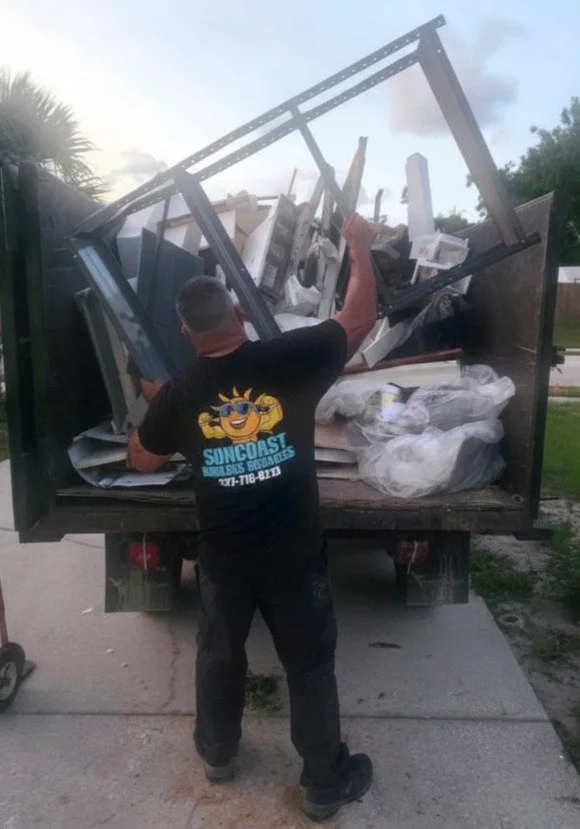 owner of suncoast hauling services loading dumpster trailer in pinellas county