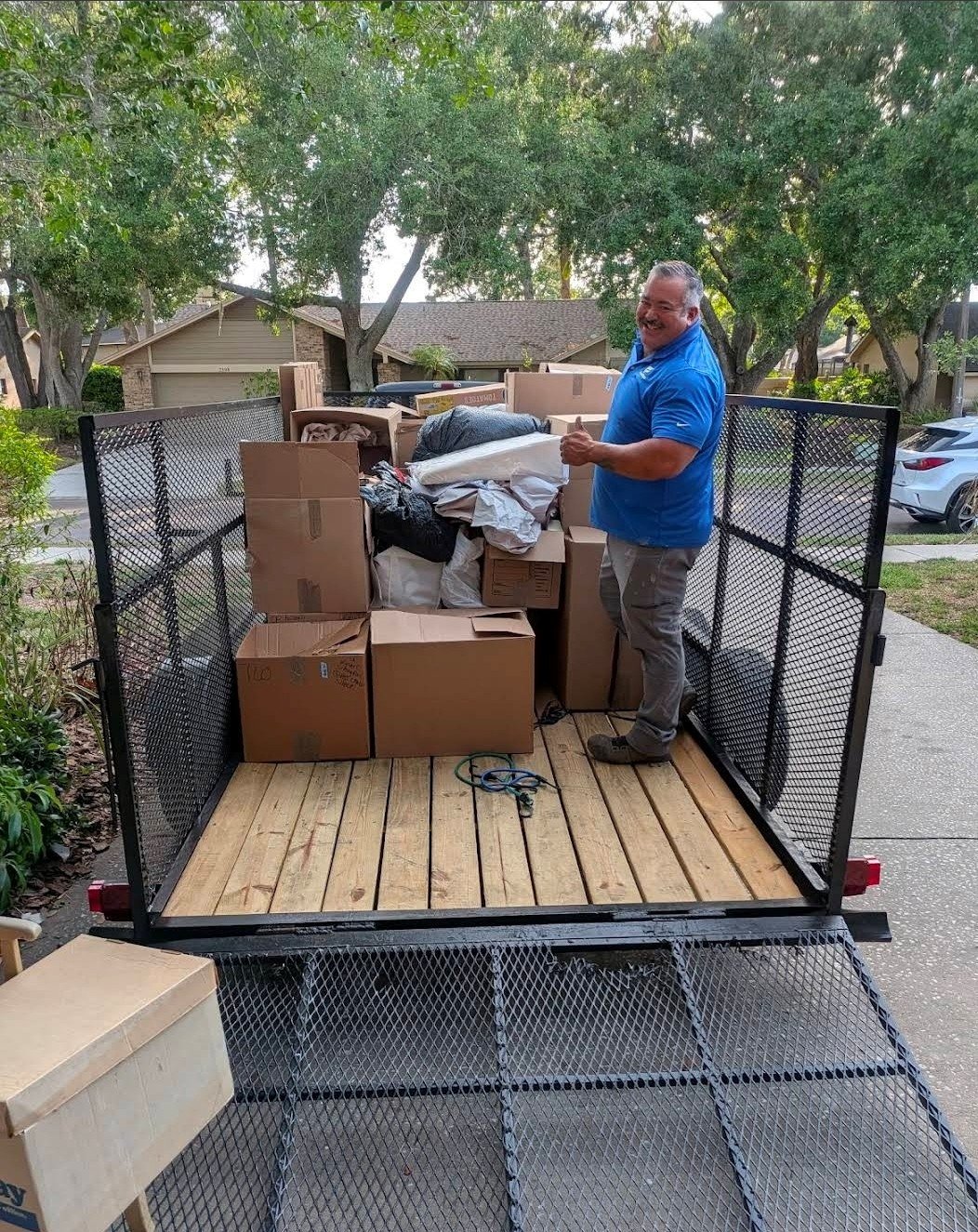 Suncoast Hauling Services loading a junk removal trailer in Palm Harbor, FL