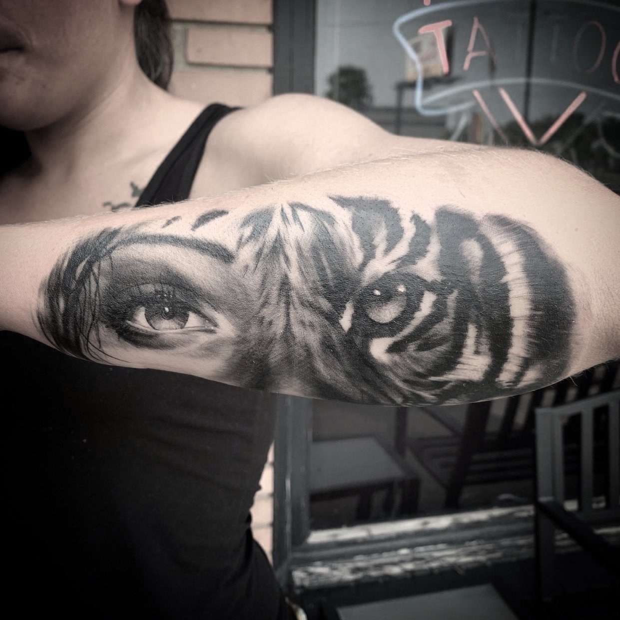 Close-up of a person's arm with a detailed black and gray tattoo of a human eye and tiger stripes. Tattoo, tattoo artist, tattoos, realistic tattoo, portrait tattoo, artistic tattoo, experienced tattoo artist, Oregon, tattoo artist near me, nature ta