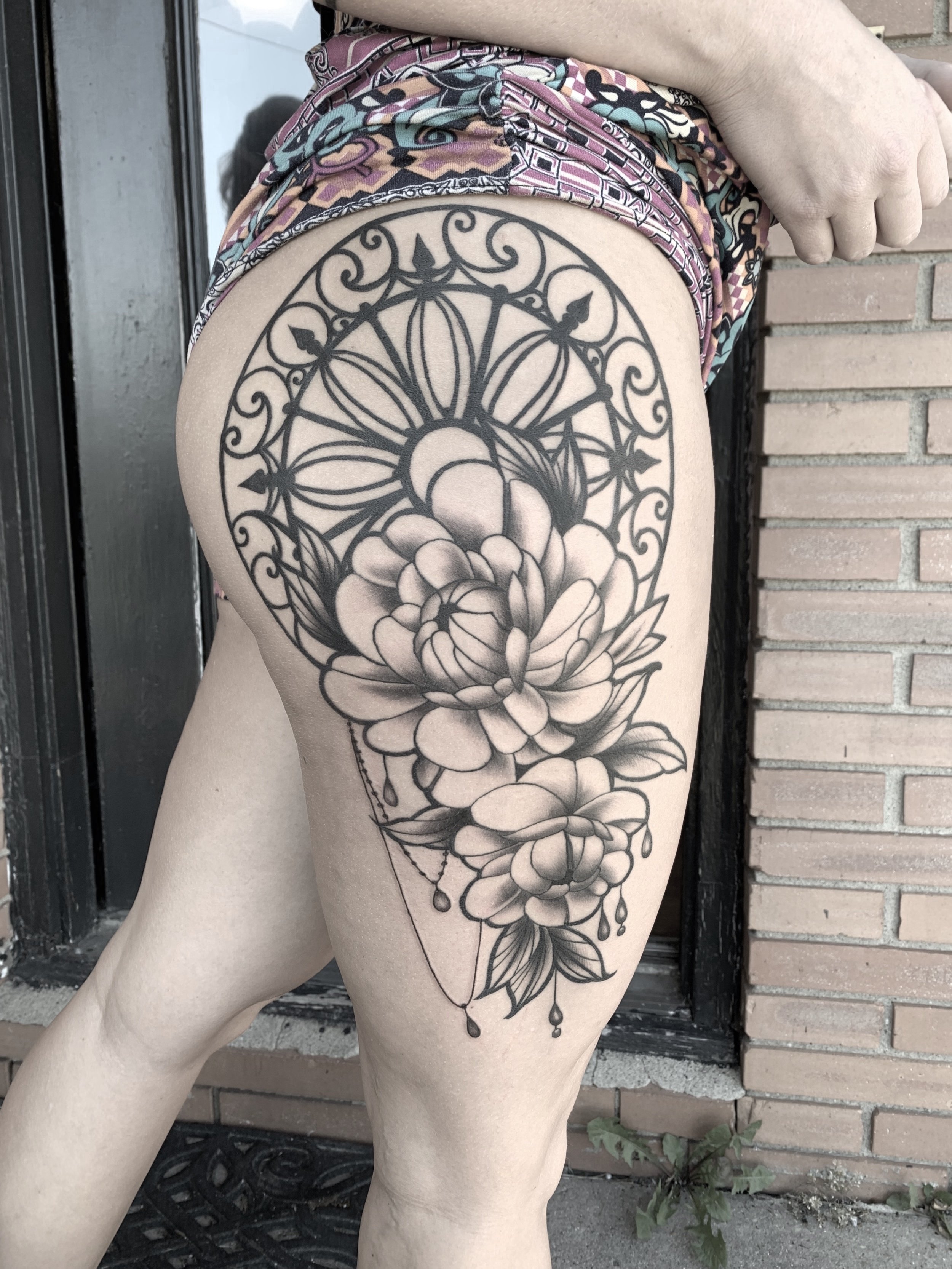 Black and gray floral tattoo on person's upper thigh featuring large peonies with geometric and decorative elements. Tattoo, tattoo artist, tattoos, realistic tattoo, portrait tattoo, artistic tattoo, experienced tattoo artist, Oregon, tattoo artist