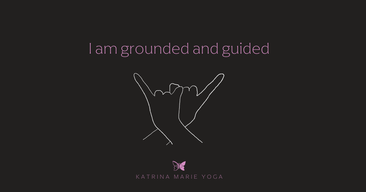 Black background with pink text reading “I am grounded and guided” above a white line drawing of hands in Rupa Mudra, with a small butterfly icon and “Katrina Marie Yoga” below.