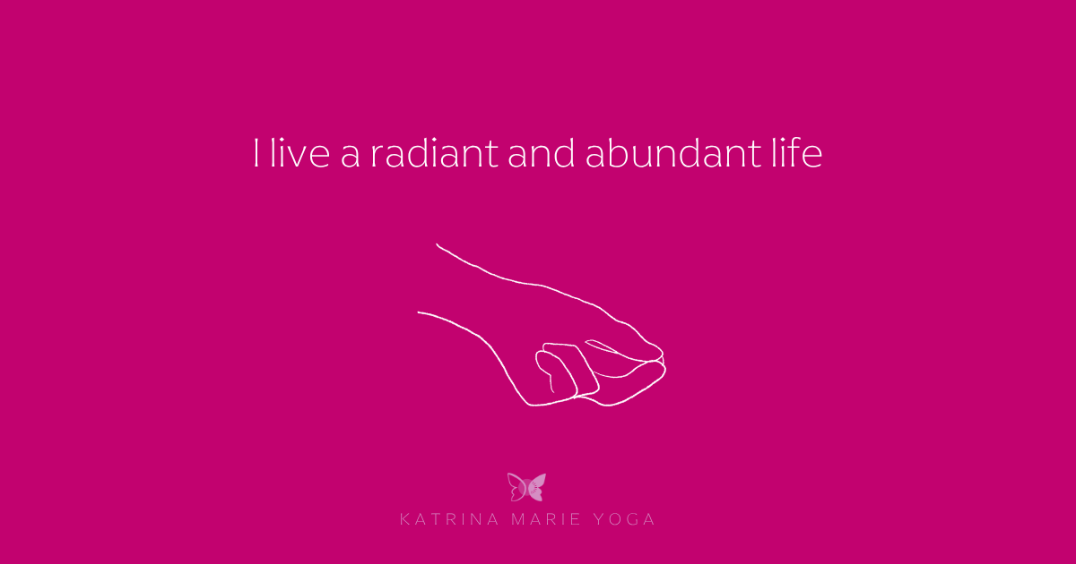Kubera Mudra mantra graphic on a magenta background. White text reads I live a radiant and abundant life. A hand-drawn sketch of Kubera Mudra appears below the text. The Katrina Marie Yoga butterfly logo appears at the bottom.