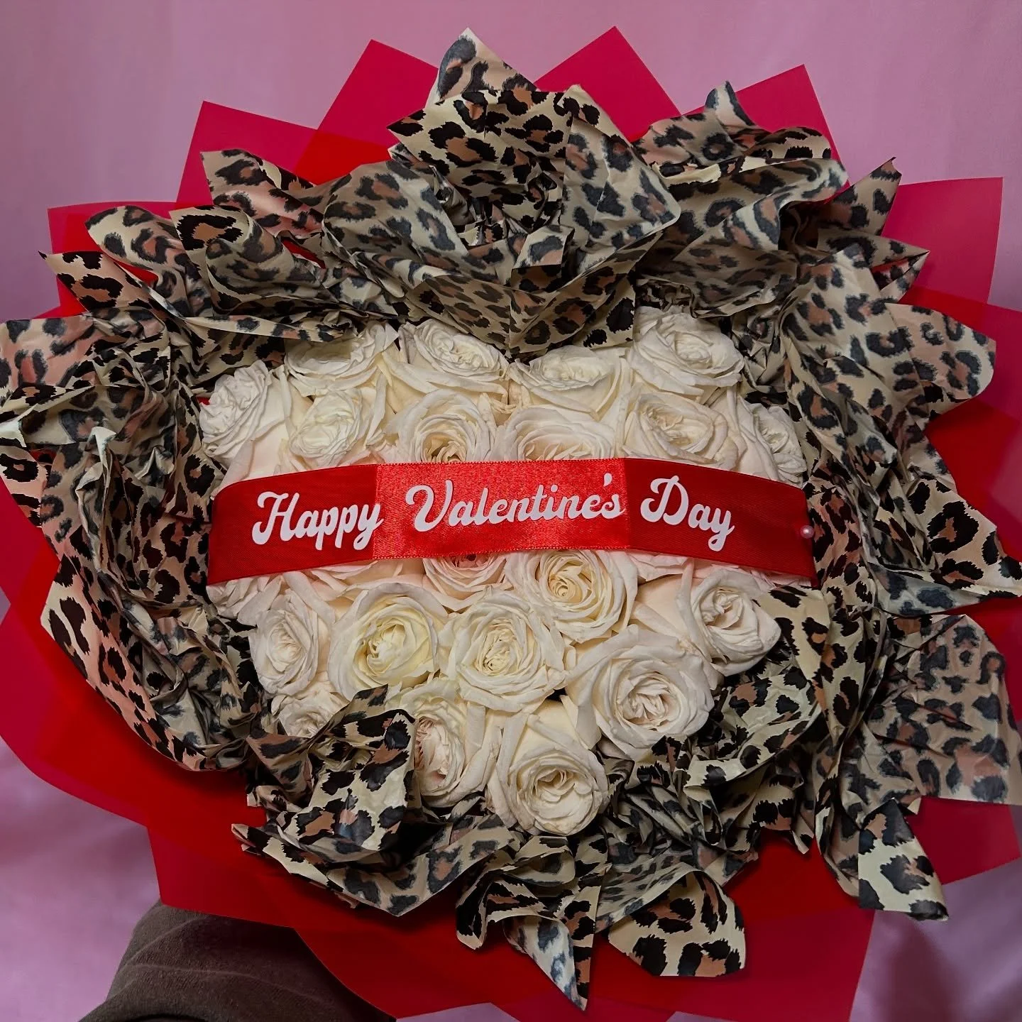 red wrapping paper and leopard tissue paper hugging a heart shaped white rose bouquet🤍❣️