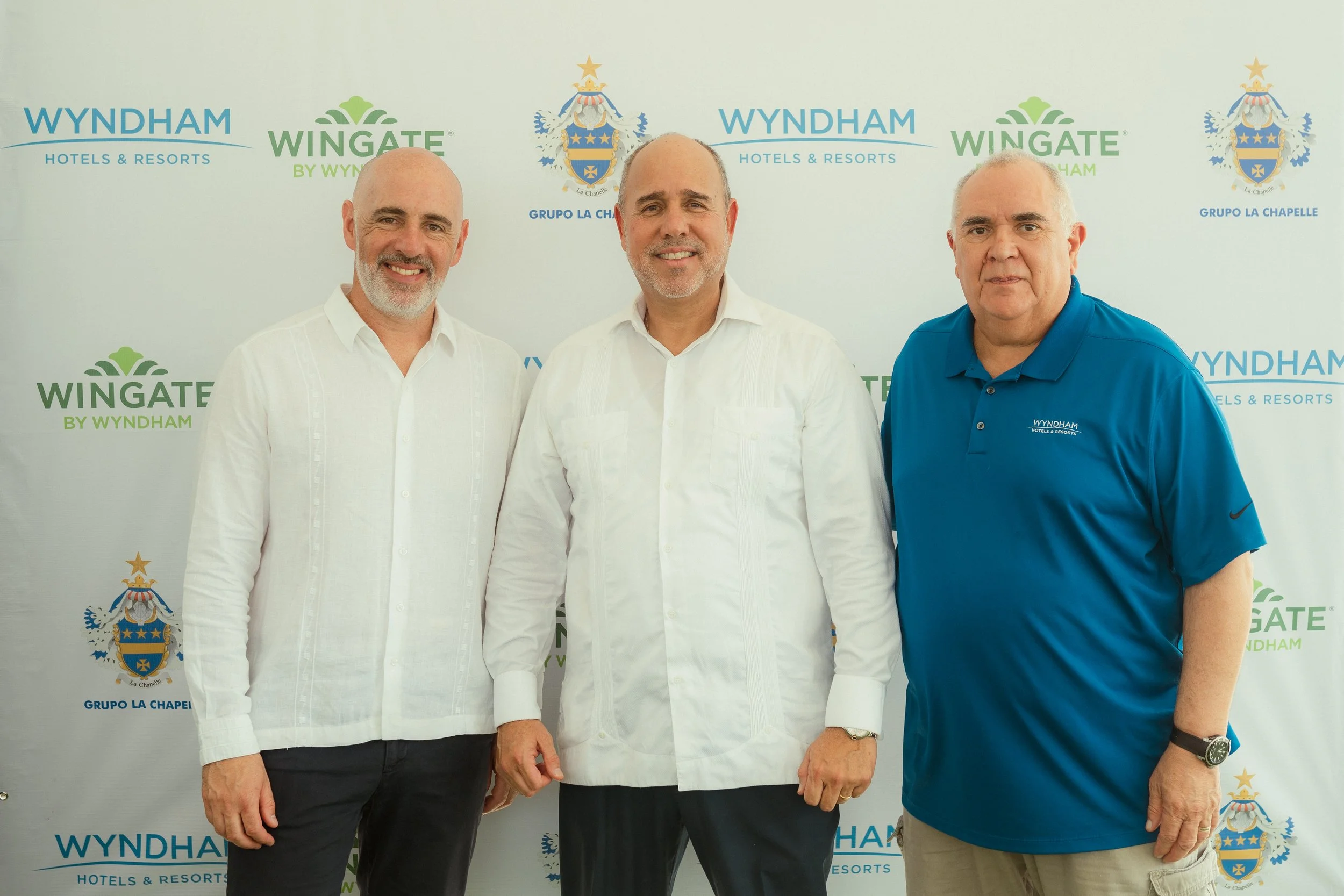 Gustavo Viescas, Nigel P. La Chapelle V., and Louis Alicea at a Wingate by Wyndham Punta Cana investment event, discussing branded condo-hotel opportunities with 8%-12% ROI.