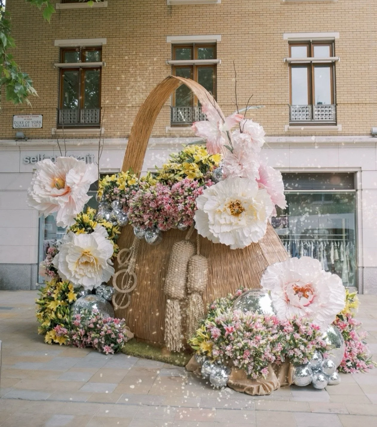 Our second installation for Chelsea Flower Show this year was a giant handbag! Woven out of willow, standing 6m tall with the handle arching up overhead, we filled it with thousands of bright open, double Lillies, hundreds of glitter balls and our be