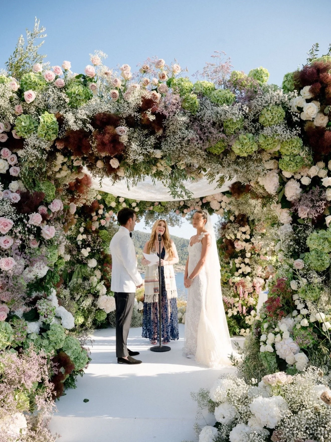 Sun-soaked vows beneath the most beautiful chuppah in Ibiza. 💫 
.
.
.

@islaandsmithbespokeevents
@tali__photography
@sixsenses.ibiza
@hedges16

#allforlovelondon #lovemademedoit #ibizawedding #destinationwedding #rooftopceremony luxurywedding