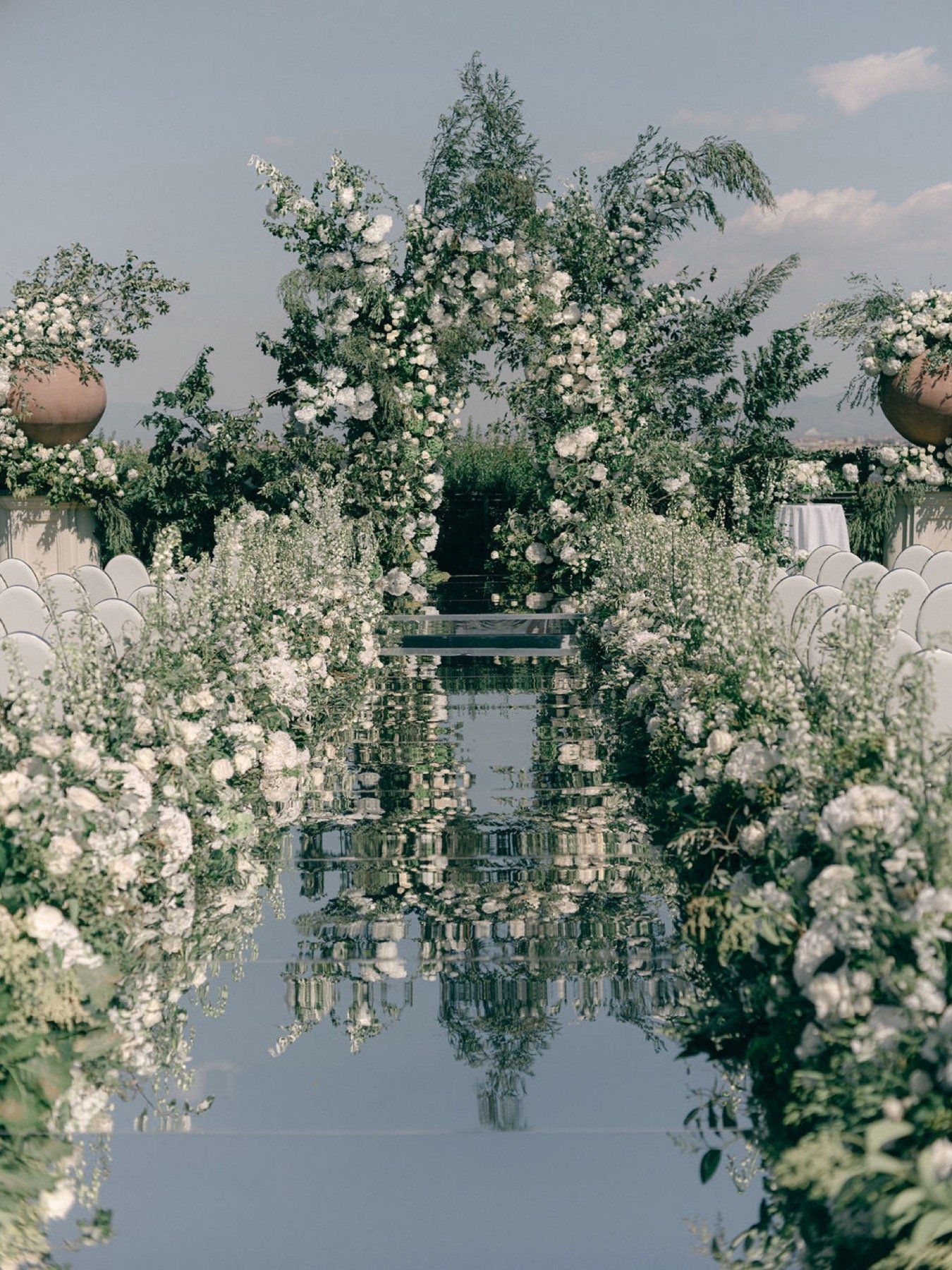 all-white-wedding-ceremony-flower-installation-mirrored-aisle.jpg